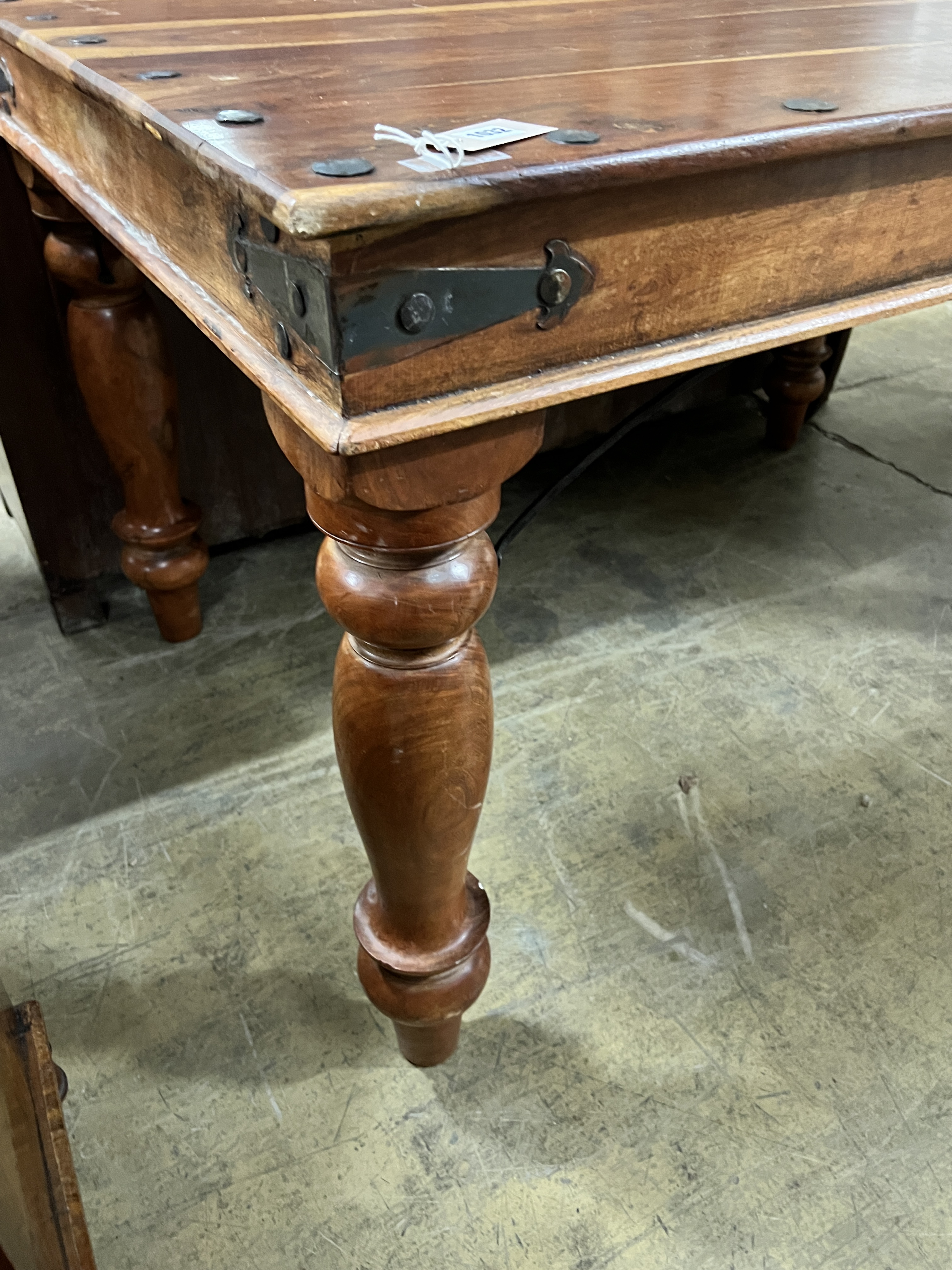 A rectangular Indonesian studded hardwood dining table, width 135cm, depth 90cm, height 79cm